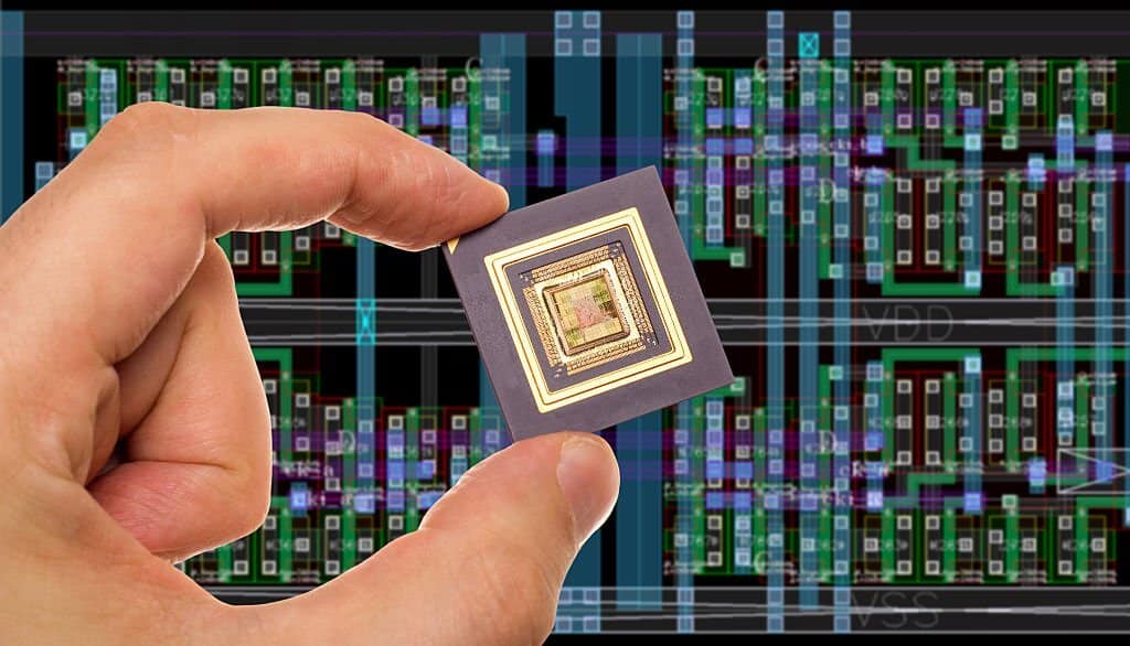 Microprocessor in hand in front of chip layout