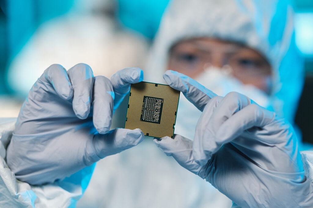 Gloved hands of contemporary scientist or it-engineer in protective workwear holding microchip